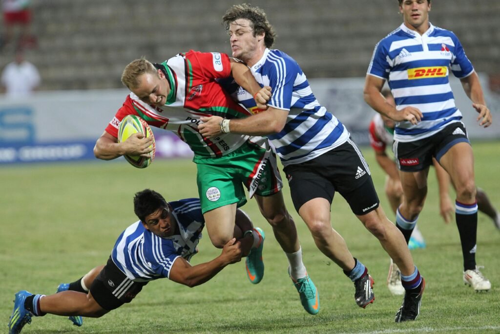 Why Do So Many Young Men Think They Have Low Testosterone? Dynamic action shot of rugby players in a fierce tackle during a lively outdoor game.
